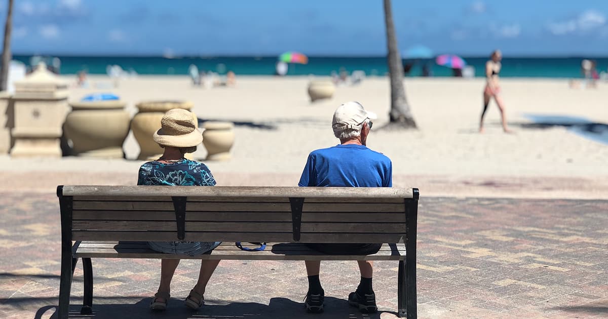 Retraités sur un banc au bord de la plage