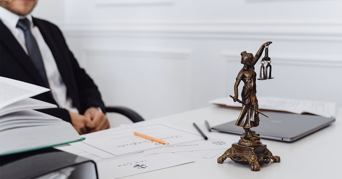 Avocat immobilier en Espagne avec documents juridiques et statue de la justice