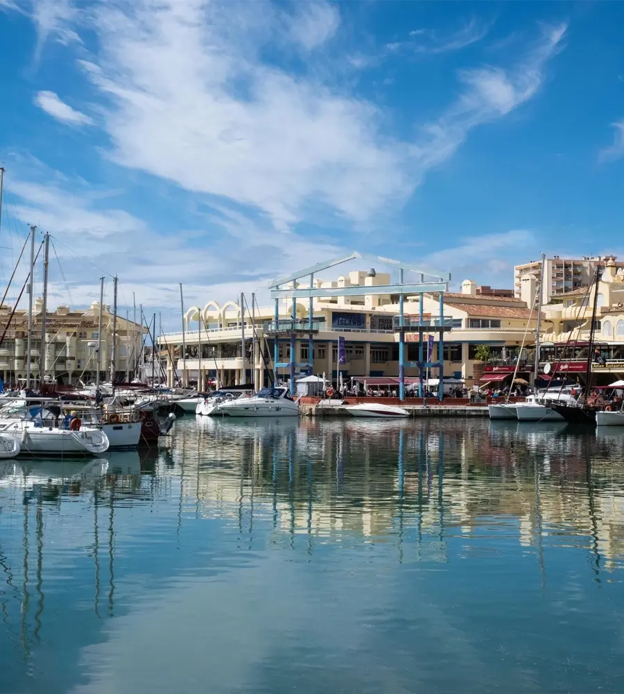 Port de plaisance de Benalmadena Port de plaisance de Benalmadena avec des bateaux amarrés et des bâtiments typiques sous un ciel bleu clair