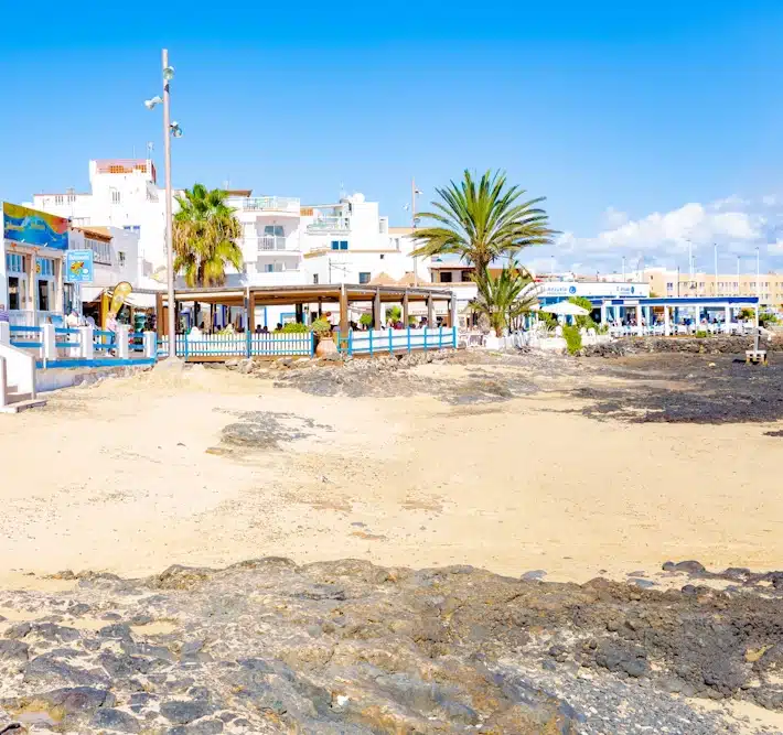 Restaurant bord de plage à Fuerteventura Petit restaurant en bord de plage à Fuerteventura, entouré de sable et de palmiers, offrant une ambiance typique de l'île