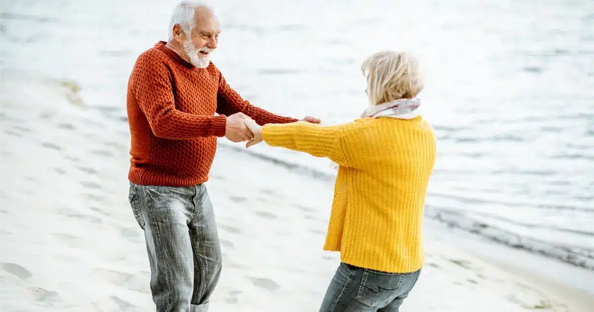 Couple de senior qui danse sur la plage