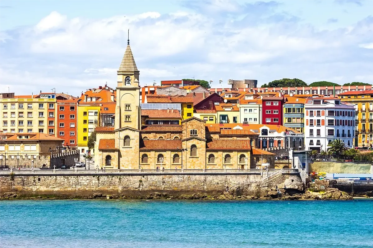 Vue de la côte avec église et maisons colorées au bord de la mer