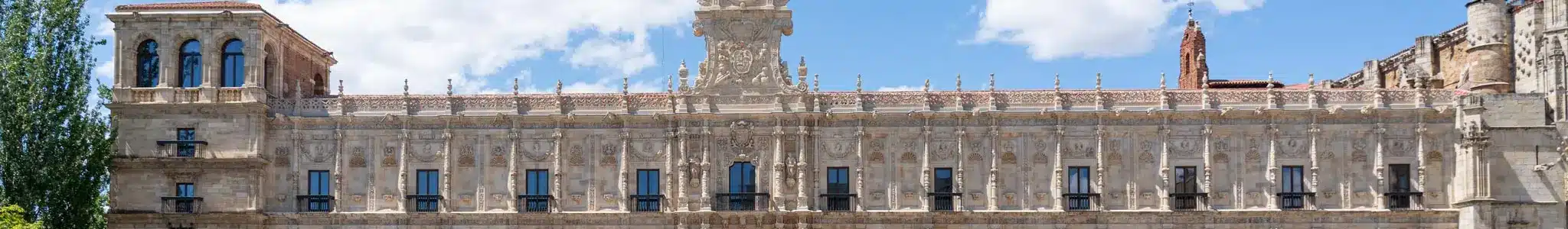 Façade ornée d’un bâtiment historique en pierre avec nombreuses fenêtres et sculptures