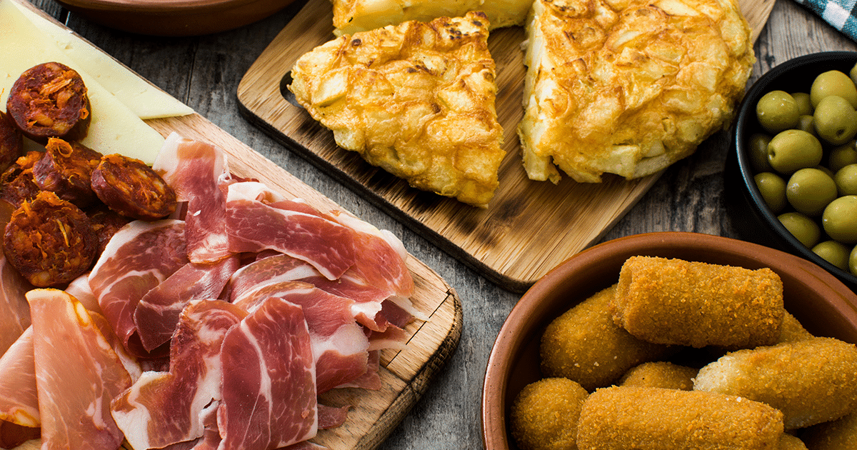 Assortiment traditionnel de tapas espagnols avec jambon ibérique, chorizo, fromage manchego, tortilla de patatas, croquetas et olives vertes