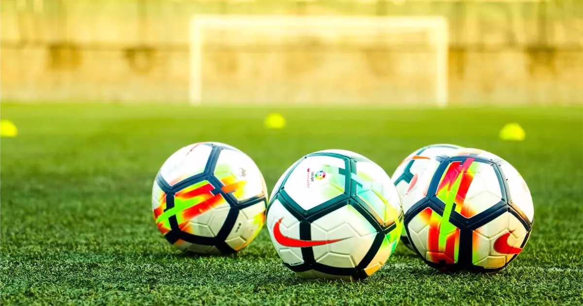 ballons-de-foot-terrain-espagne Ballons de football sur un terrain en Espagne, illustrant la culture sportive et l’importance du foot