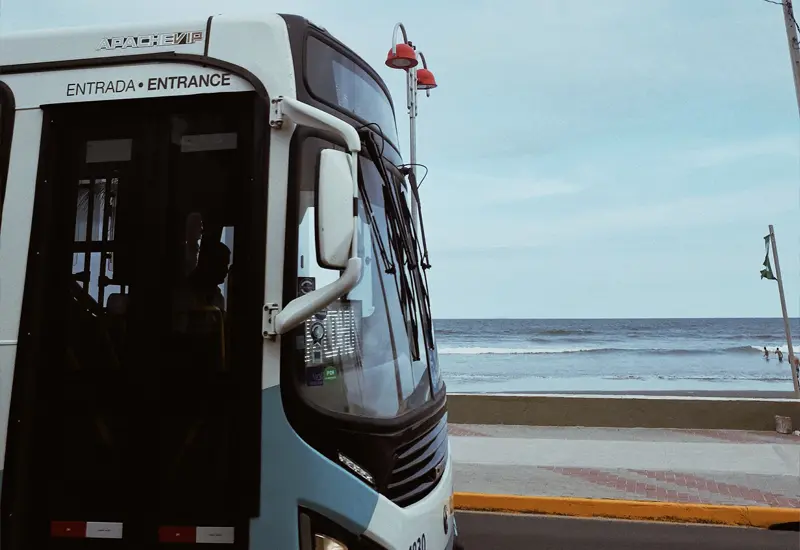 Bus en Espagne circulant en bord de mer, illustrant le coût de la vie et les transports publics