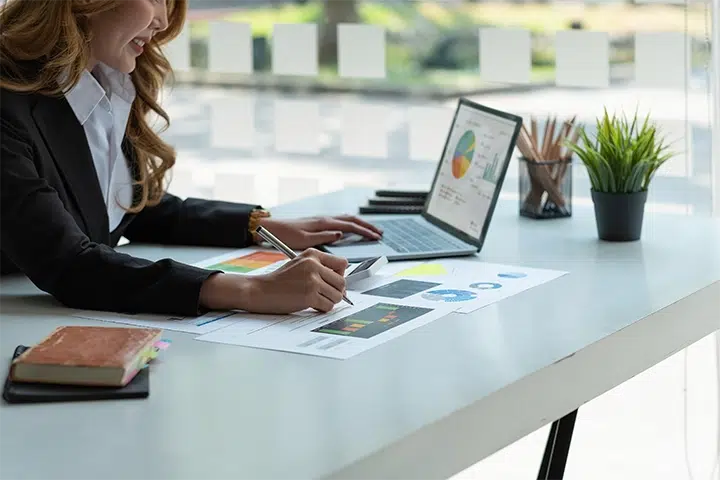 Conseillère analysant les implications fiscales d’un prêt hypothécaire en Espagne sur ordinateur avec graphiques financiers