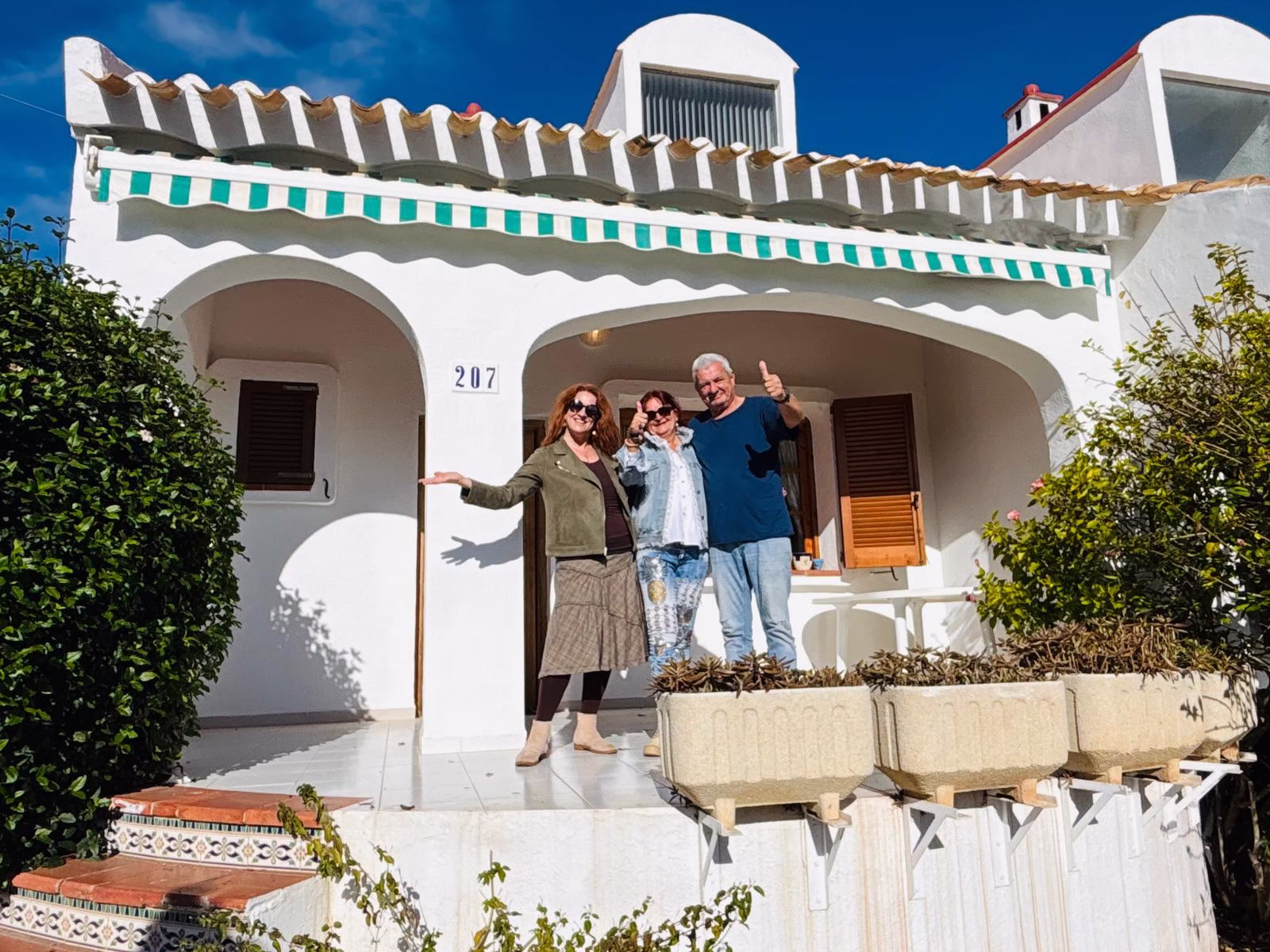 Chasseuse immobilier avec ses clients devant une maison à Alcossebre